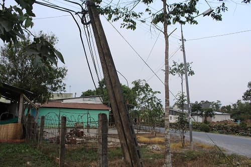 Hàng loạt cột điện nghiêng cạnh nhà dân